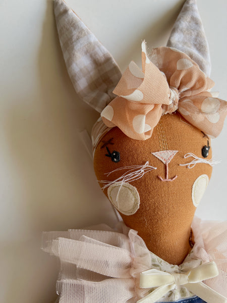 bespoke bunny doll with a dress on a light gray background up-close face detail