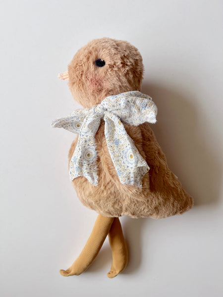 faux fur chick doll with scarf on a light background