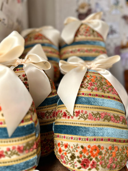 Decorative Easter eggs with floral and striped patterns tied with ribbons.