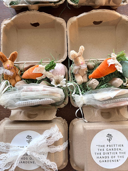 Easter-themed gift sets in cardboard egg carton with bunnies, carrots, and flowers.