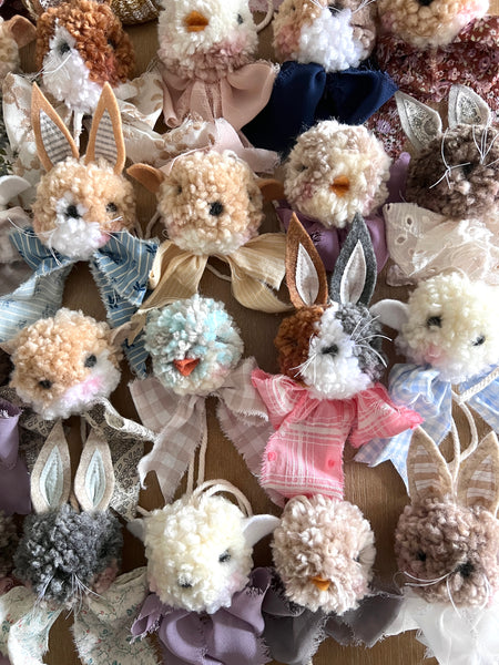 Collection of small plush toys with rabbit ears and various colors on a textured background