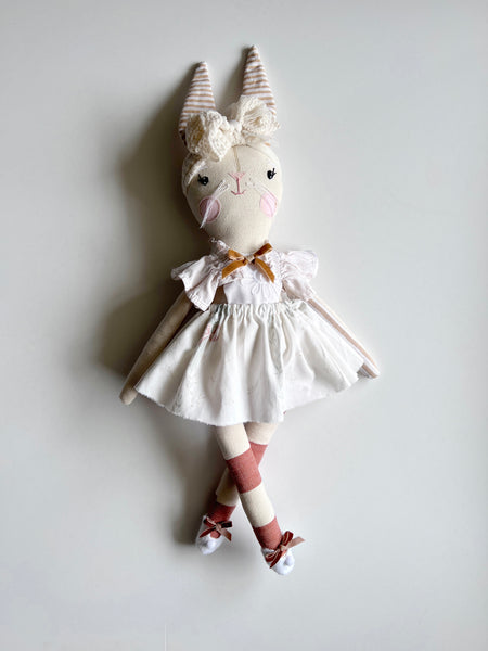 bespoke bunny doll with a white dress on a light gray background