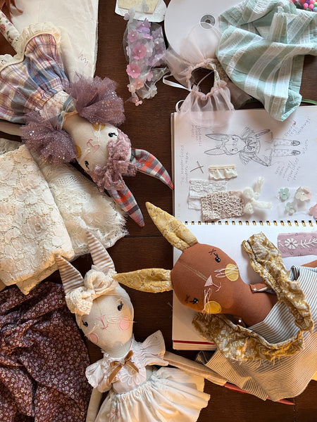 Handmade dolls and a notebook with illustrations on a wooden surface