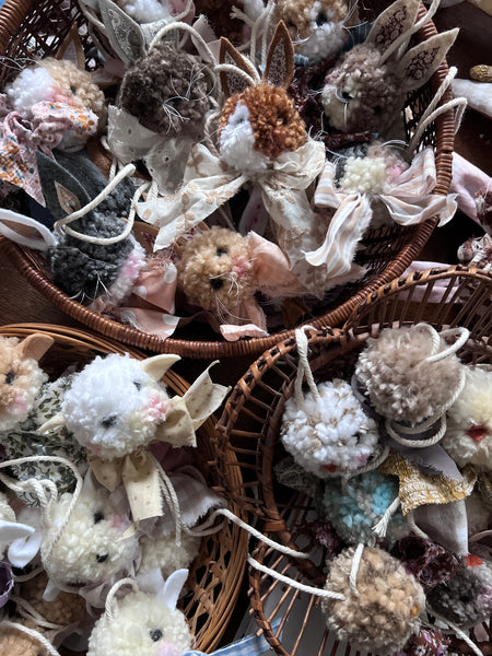 Decorative pom pom animals in woven baskets.