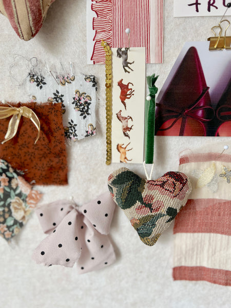 Collection of decorative items including fabric hearts and ribbons on a textured surface.